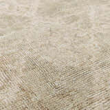 Close up of the Fetscher IV Vintage Damask Area Rug showing its light brown, olive, and peach tones and soft texture. Texture