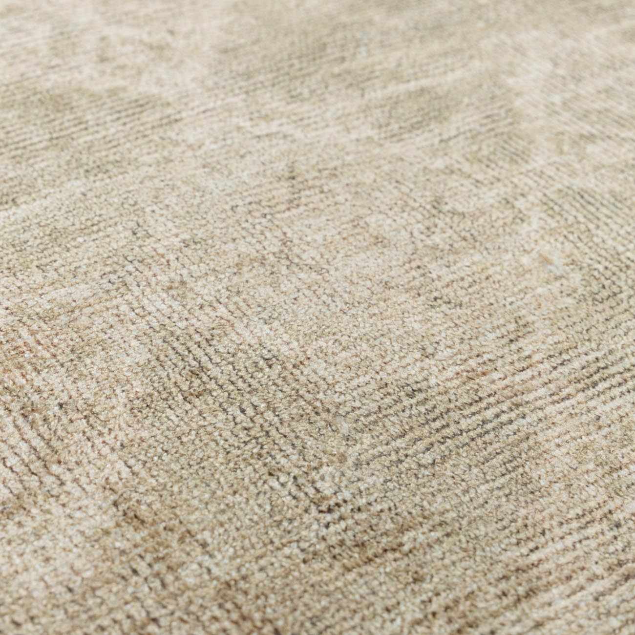 Close up of the Fetscher IV Vintage Damask Area Rug showing its light brown, olive, and peach tones and soft texture. Texture