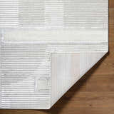 Close-up of the Atalie Area Rug showing its cream, ivory, and gray stripes and geometric pattern. Fold