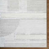 Close-up of the Atalie Area Rug. Cream, ivory, and gray horizontal stripes create a contemporary pattern. Soft, textured weave. Corner