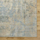 Close up of Greenhills Handmade Wool Area Rug showing beige, charcoal, and blue abstract pattern and wool texture. Corner