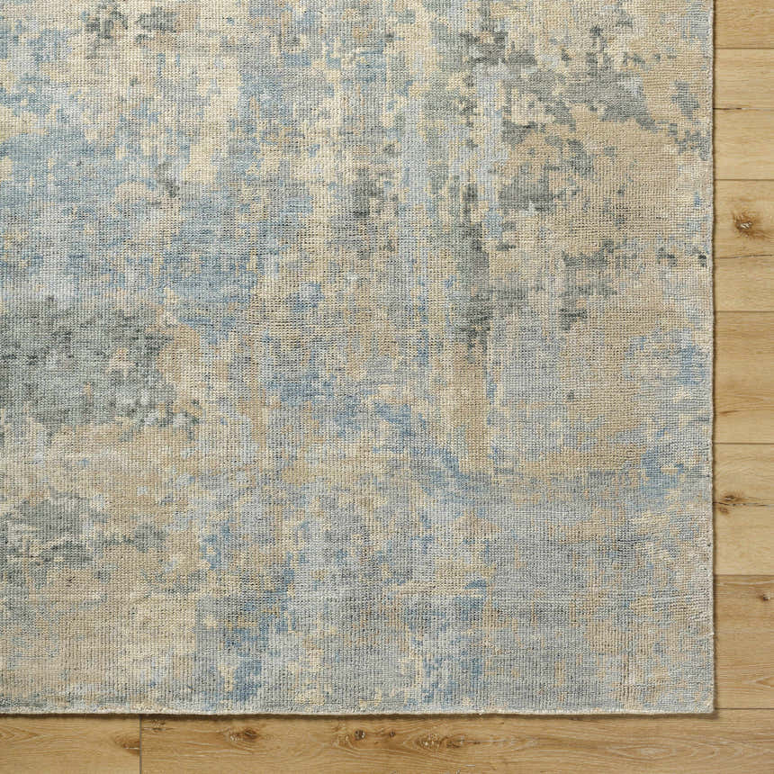 Close up of Greenhills Handmade Wool Area Rug showing beige, charcoal, and blue abstract pattern and wool texture. Corner