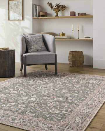 Living room scene with a gray chair and the Alyson Vintage Flat Pile Washable Rug in cream, green, plum, and tan. Roomscene-Rectangle