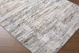 Close-up of Aurera Area Rug. Contemporary design with black, ivory, gray, and brown tones. Machine woven texture. Corner