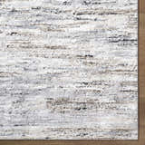 Close-up of the Aurera Area Rug. Contemporary design in ivory, black, brown, and gray on a machine-woven polypropylene rug. Corner