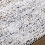 Close-up of the Aurera Area Rug. Contemporary style with black, ivory, brown, and gray hues. Machine woven texture. Texture