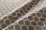 Close-up of the Haddix Premium Leather Rug. Beige, cream, and gray hexagons create a contemporary, animal-inspired pattern. Styleshot