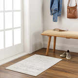 Entryway scene with Livabliss Harput HAP-1024 charcoal and gray area rug, bench, wood floors, and white walls. Roomscene-Rectangle