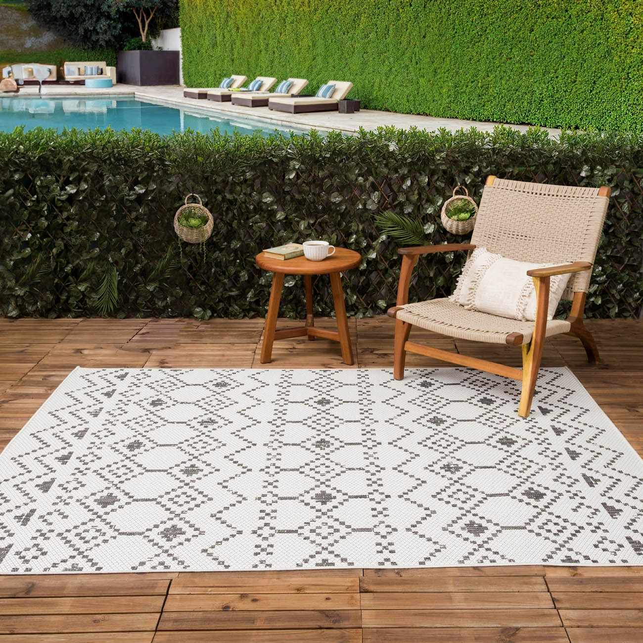 Outdoor patio scene with Haynesville Moroccan Design Pixel Rug, chair, and pool backdrop. Roomscene-Rectangle