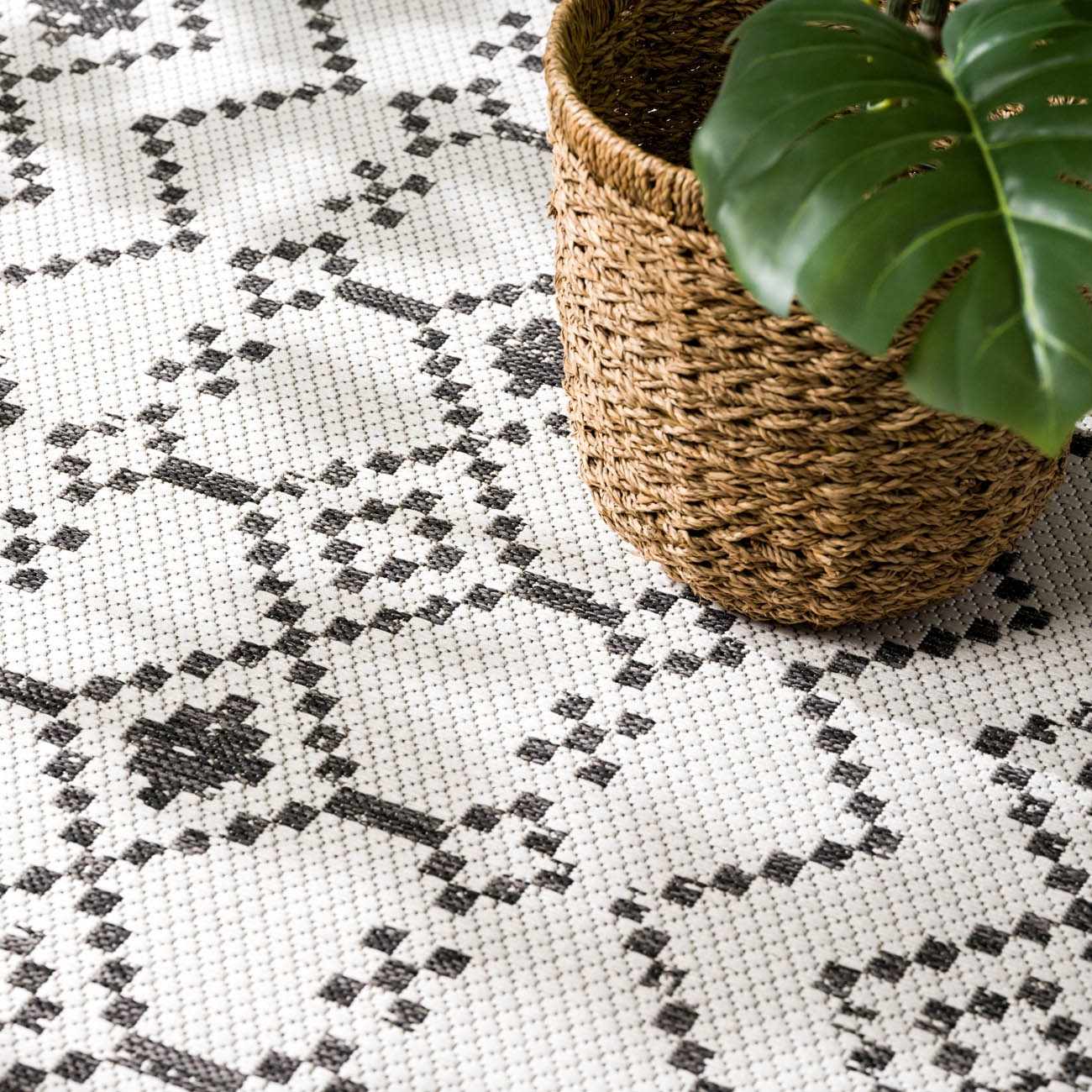 Close-up of Haynesville Moroccan Design Pixel Rug. Black pixelated pattern on white polypropylene. Woven texture. Styleshot
