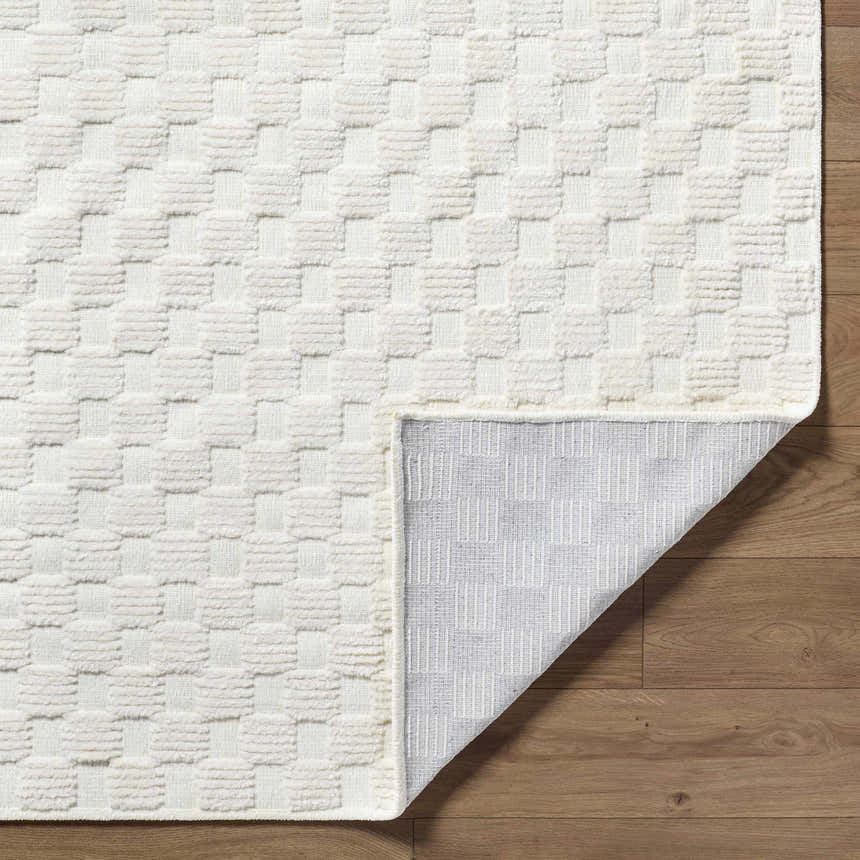 Close-up of the Anthea Off-White 3D Checkered Washable Rug showing the textured, geometric design and durable backing. Fold