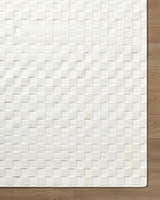Close-up of the Anthea Off-White 3D Checkered Washable Rug. The rug has a raised, textured geometric pattern. Corner
