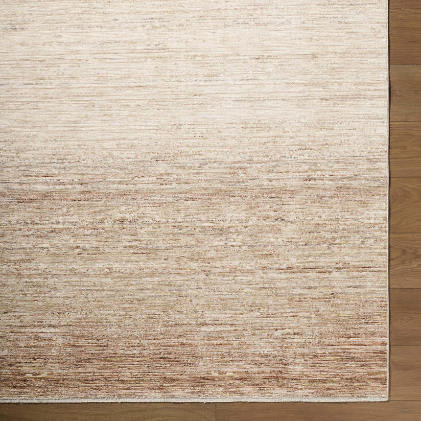 Close-up of the cream, dark brown, and gray textured Amaury Area Rug on a wood floor. Corner