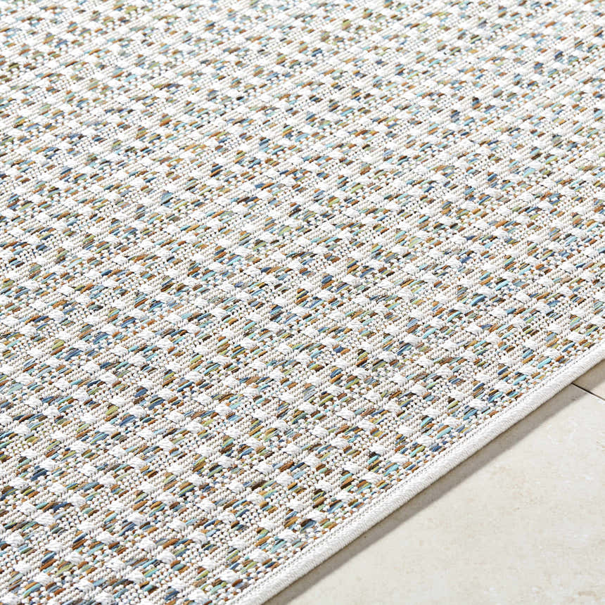 Close-up of the Ataret Ivory Area Rug. Features a woven texture with ivory, tan, blue, and gray hues. Texture