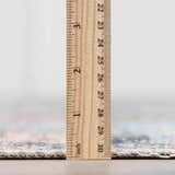 Close-up of the pile height of the Blue Burgundy Holi-2302 Washable Area Rug with a ruler showing the thickness. Pile
