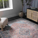 Living room scene with a Blue Burgundy Holi-2302 rug, beige chair, and rattan cabinet. The rug features a vintage Persian design. Roomscene-Rectangle