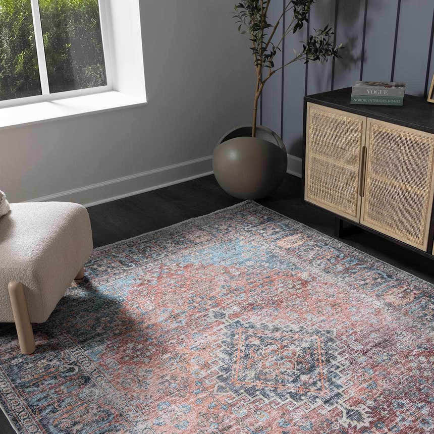 Living room scene with a Blue Burgundy Holi-2302 rug, beige chair, and rattan cabinet. The rug features a vintage Persian design. Roomscene-Rectangle