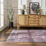 Living room scene with a Burgundy Holi-2303 Washable Area Rug, wood floors, and a light wood cabinet. Cactus and modern art add style. Roomscene-Rectangle
