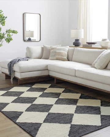 Living room scene with a beige sectional and the black and beige checkered Andrin Area Rug. Roomscene-Rectangle