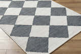 Close-up of the Andrin Gray Area Rug. Beige and steel gray jute rug with a hand-woven checkered pattern. Corner