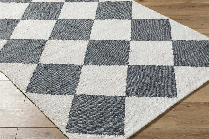 Close-up of the Andrin Gray Area Rug. Beige and steel gray jute rug with a hand-woven checkered pattern. Corner
