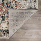 Close-up of the Dorval Traditional Rug showing its brick red, cream, and navy oriental pattern and machine-woven construction. Fold