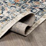 Close-up of rolled Dorval Traditional Rug showing cream, denim, and rust colors in an oriental pattern. Fold