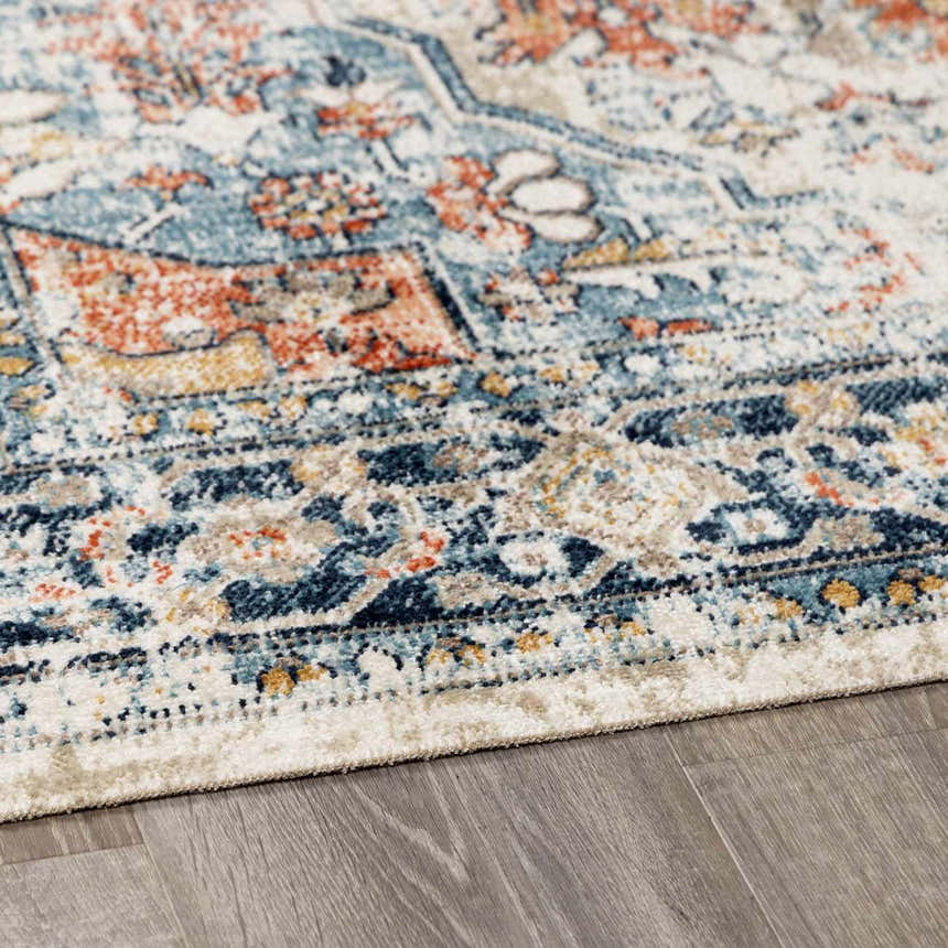 Close-up of the Dorval Traditional Rug. Features brick red, cream, denim, and navy hues in an intricate oriental pattern. Corner