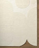 Close up of the ivory Jgadve rug. Hand tufted wool rug with abstract circle design and horizontal lines. Corner