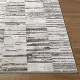 Close-up of the Apphia Area Rug. Contemporary style rug with an ivory and light brown pattern on a wood floor. Front