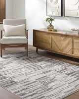 Living room scene with ivory and light brown Apphia Area Rug, light wood furniture, and neutral decor. Roomscene-Rectangle