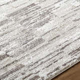 Close up of the Apphia Area Rug, featuring an ivory and light brown contemporary pattern. Texture