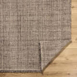 Close-up of the hand woven Pufoe Modern Wool Area Rug showing texture and detail on a wood floor. Fold