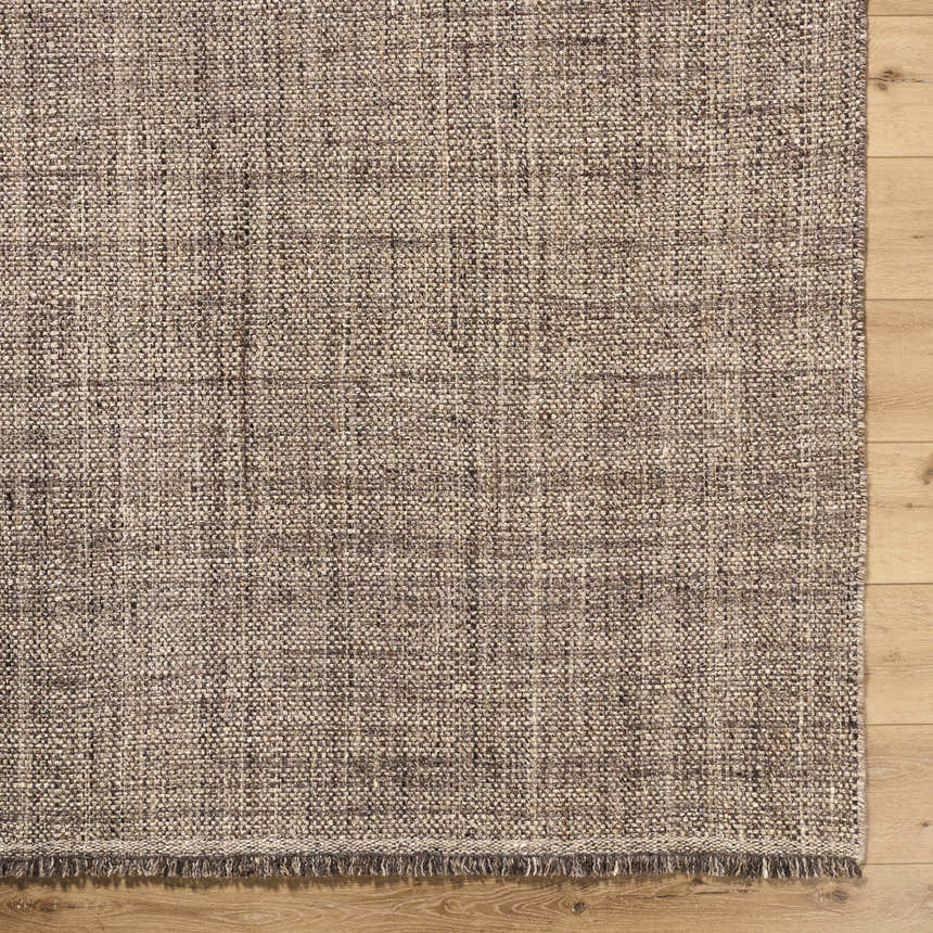 Close up of the hand woven texture and fringe of the Pufoe Modern Wool Area Rug on wood floor. Corner