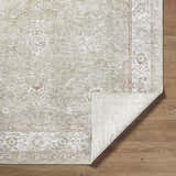 Close-up of the machine-woven Ashraf Area Rug. Farmhouse style, traditional pattern, neutral colors, polyester texture. Fold