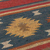 Close-up of the hand woven Hedon Wool Area Rug. Features brick red, navy, and tan colors in a Southwestern pattern. Texture