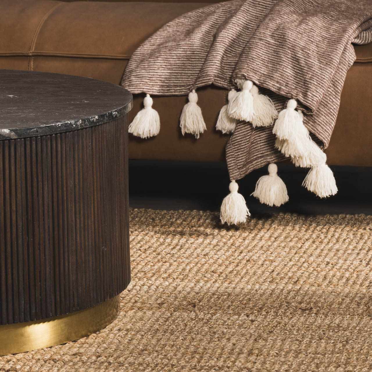 Close-up of the woven texture and natural beige color of the Oaks Perfect Flatweave Jute Rug in a styled living room. Styleshot