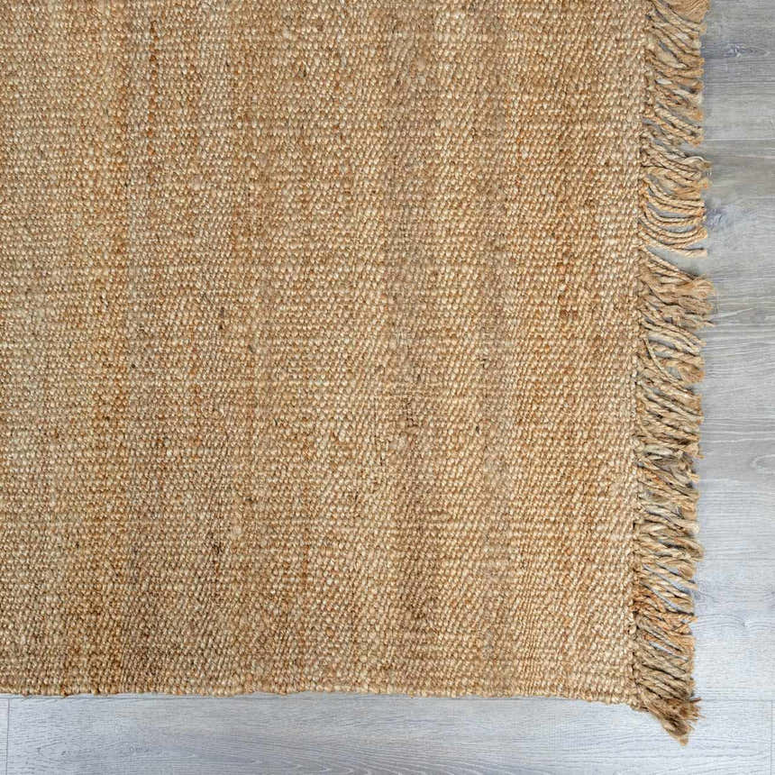 Close-up of the beige, hand-woven Oaks Perfect Flatweave Jute Rug showing texture and fringe detail. Swatch