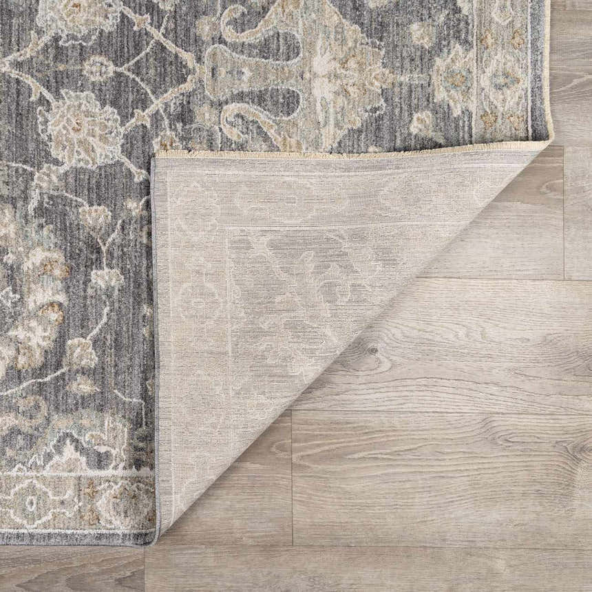 Close up of the Kanimbla Thick Luxe Avant Garde Rug showing its gray, beige, and floral pattern and woven backing. Fold