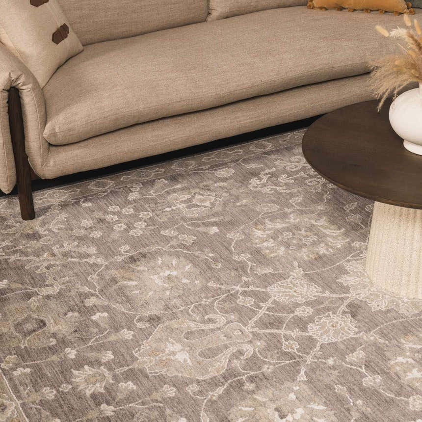 Living room scene with beige sofa and Kanimbla Thick Luxe Avant Garde Rug in gray and beige floral pattern. Styleshot