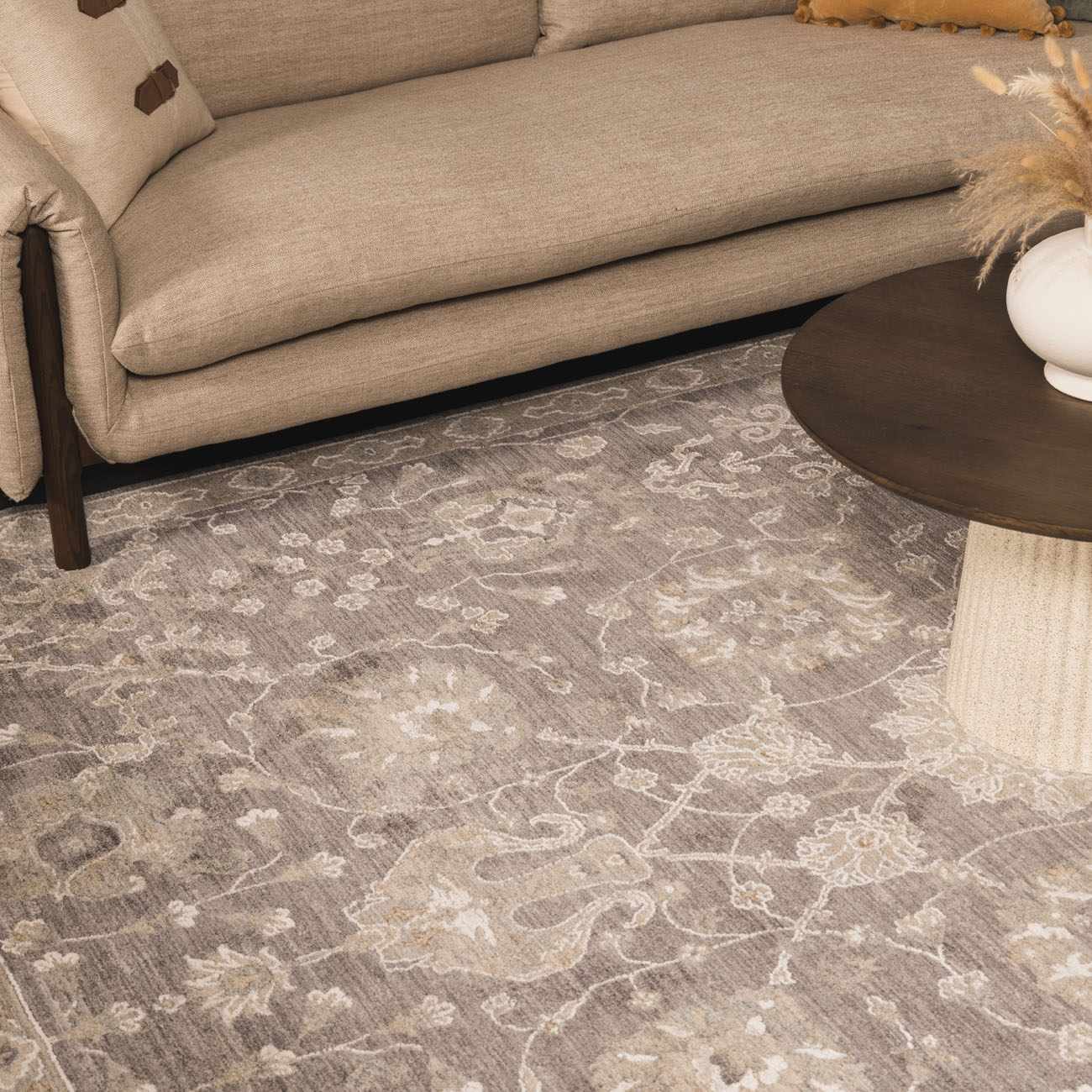 Living room scene with beige sofa and Kanimbla Thick Luxe Avant Garde Rug in gray and beige floral pattern. Styleshot