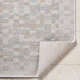 Close-up of the Arshad Ivory Area Rug showing beige, tan, and light gray woven pattern and rug backing. Fold