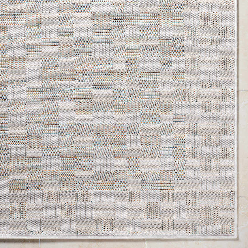 Close-up of the Arshad Ivory Area Rug. Features a woven geometric pattern in beige, ivory, tan, and light gray. Corner