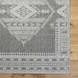 Close-up of the gray and white Asuman Area Rug showing its woven texture and traditional geometric pattern. Corner