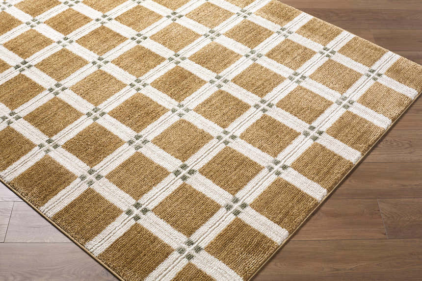 Close-up of Kalkin Light Brown Area Rug with caramel, ivory, and sage green diamond pattern on wood floor. Corner
