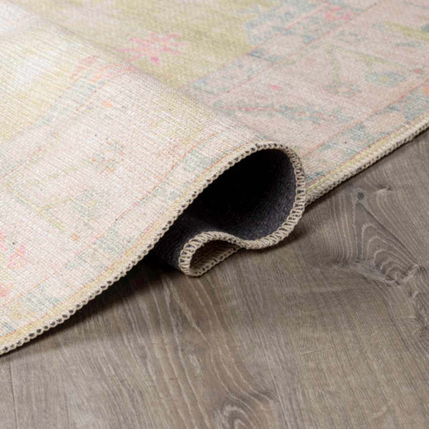 Close-up of the rolled edge of a Bozkurt Boutique Washable Rug, showing its vintage Persian pattern and polyester construction. Fold