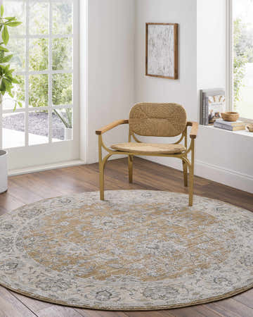 Sunlit room with Kerem Damask Thick Luxe Boutique Rug. Round rug in charcoal, cream, and brown tones under a straw chair. Roomscene-Round