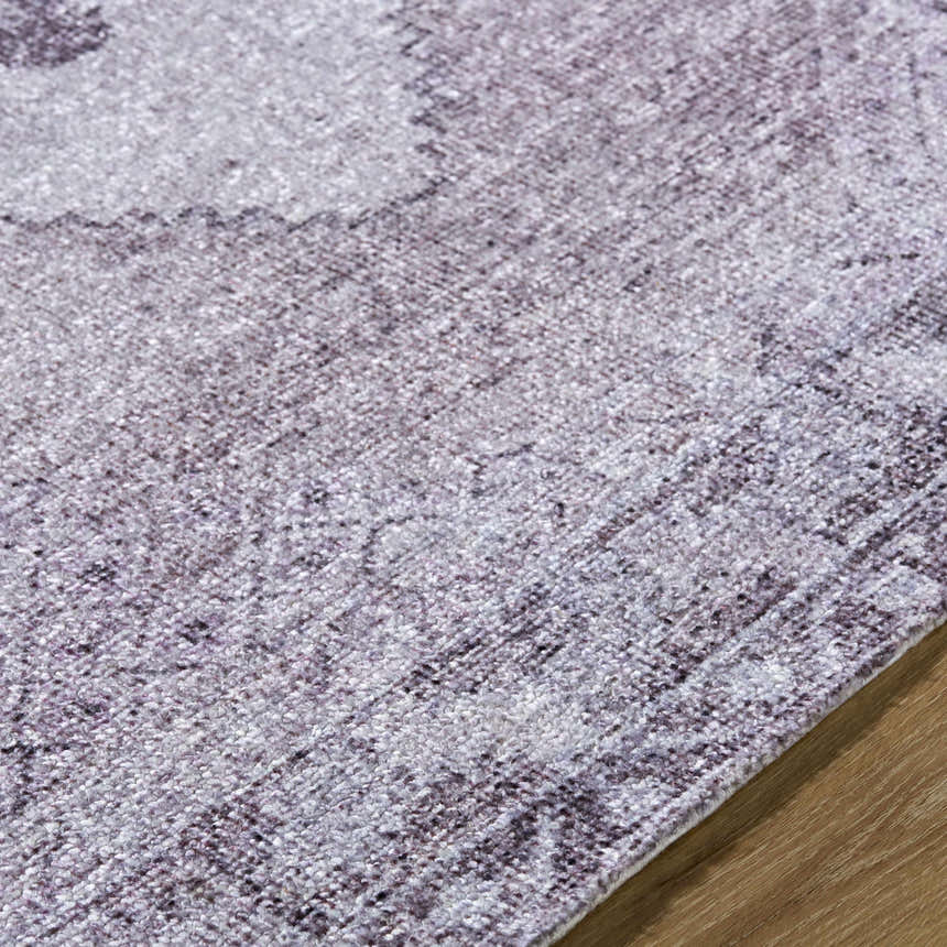 Close-up of the hand-tufted Wayde Area Rug. Features a traditional pattern in dusty rose, lavender, and mauve hues. Texture