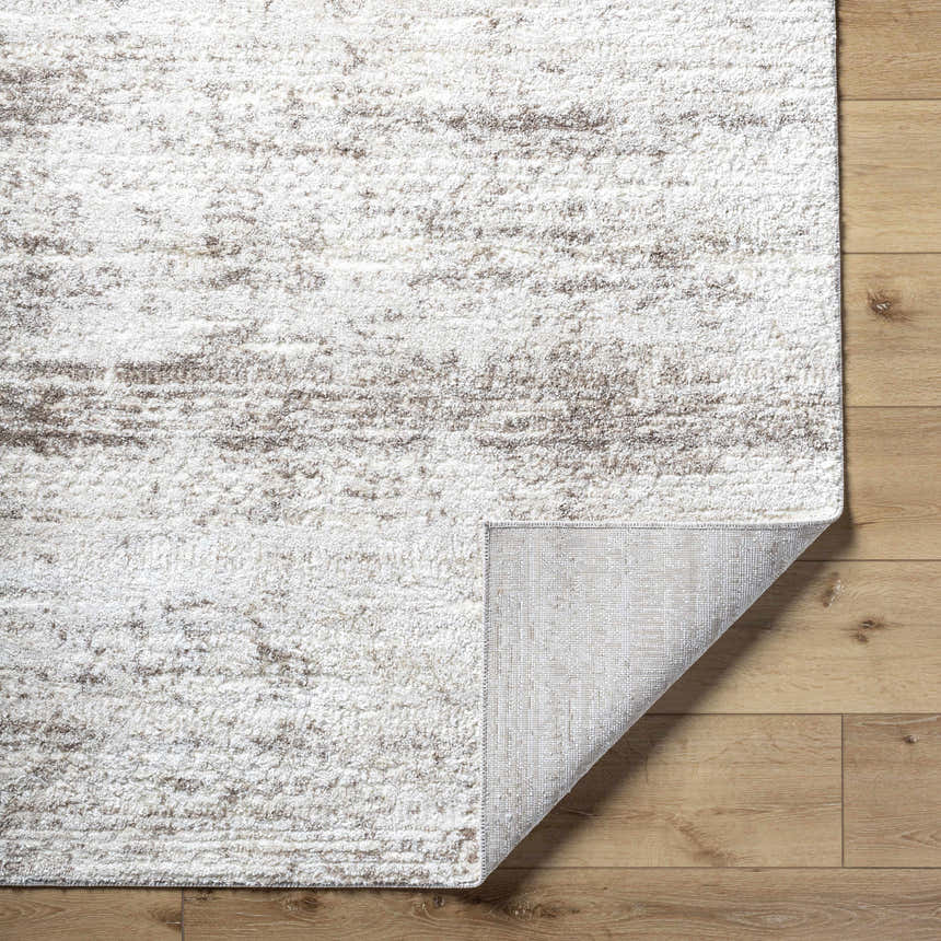 Close-up of the Kohaku Light Gray Area Rug showing its beige, ivory, and light brown abstract pattern and machine-woven texture. Fold
