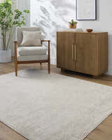 Living room scene with Livabliss x Galey Alix Maria Elena V Vintage Medallion Area Rug in ivory and tan, chair, and wood cabinet. Roomscene-Rectangle